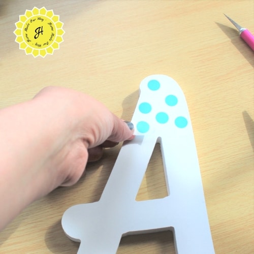 applying washi tape polka dots to wooden letter A