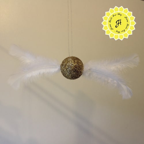 flying golden snitch suspended in air using cord