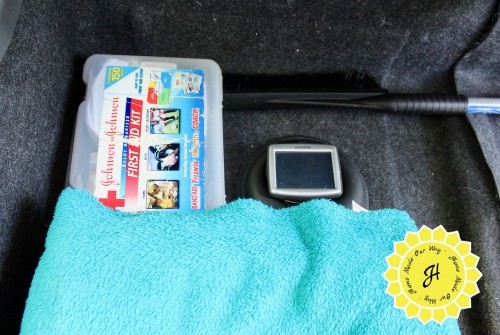 contents of car storage: first aid kit, ice scraper, gps, and blankets