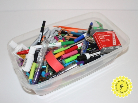 plastic bin full of desk supplies